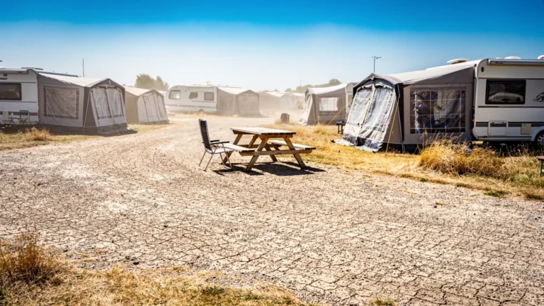 Campsite en été sans ombre avec sol brûlant, illustrant le risque de réserver un emplacement exposé au soleil